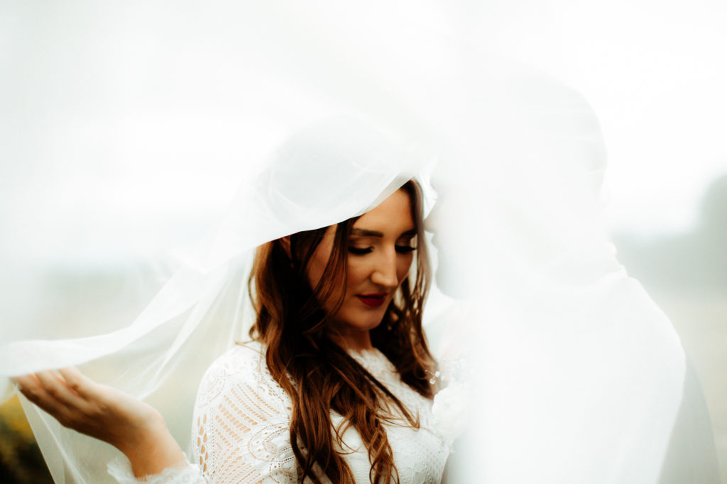 bride and groom inside of veil 